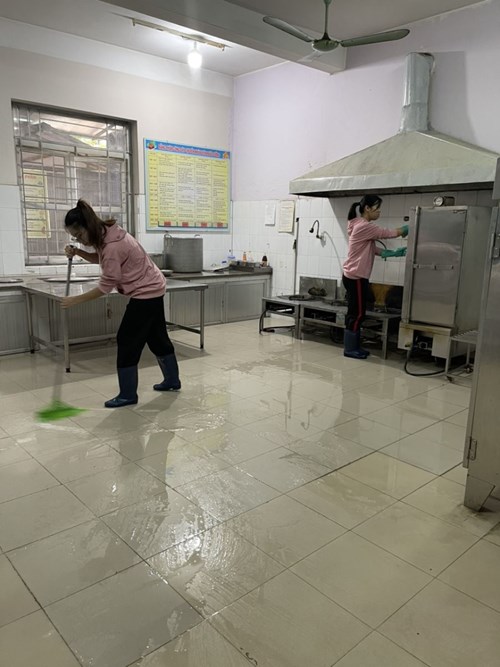 Các đồng chí nhân viên nuôi dưỡng trường Mầm non Giang Biên thực hiện công tác tổng vệ sinh môi trường trong bếp