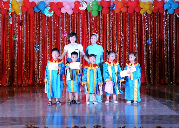 Cô hiệu trưởng - Trần Hoàng Lâm lên trao giấy chứng nhận tốt nghiệp mầm non cho các bé