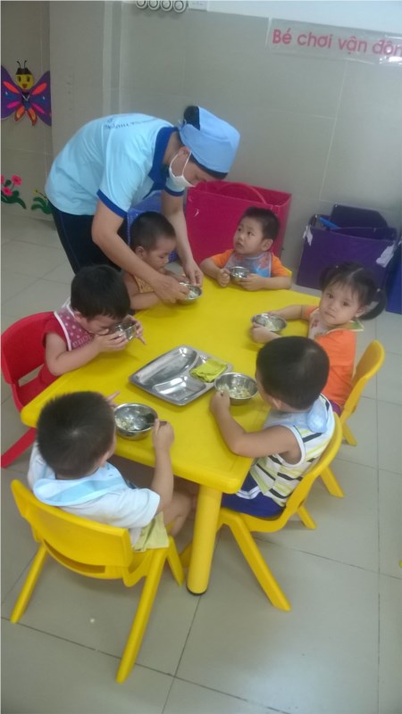 Giờ ăn cô giáo hướng dẫn các bé lớp nhà trẻ cách xúc cơm