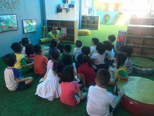 Các bé lớp mẫu giáo lớn A3 say sưa đọc sách khi tham gia hoạt động tại góc thư viện của trường