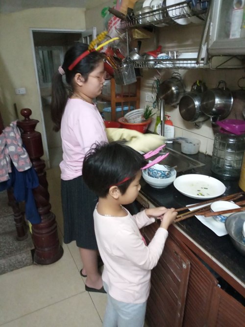 Con Nguyễn Ngọc Diệp cùng chị giúp bố mẹ rửa bát. 