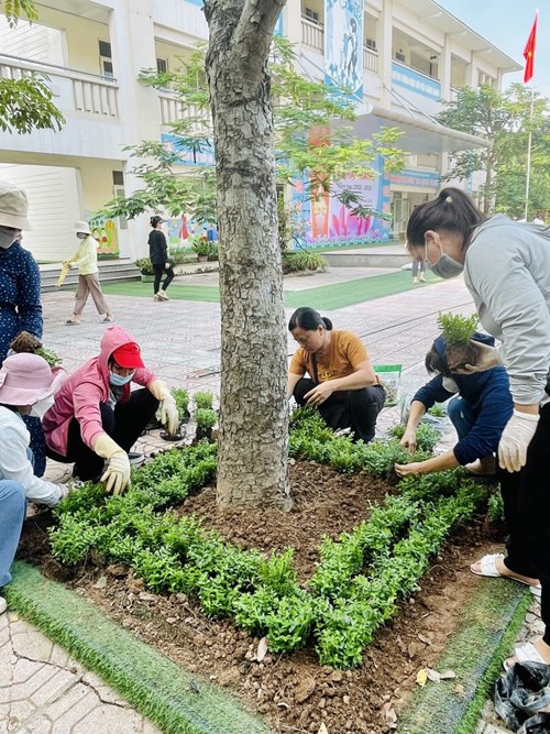 Cán bộ, giáo viên, nhân viên Trường Tiểu học Giang Biên hang hái tham gia phong trào trồng và chăm sóc hoa và cây xanh đón mừng năm học mới.